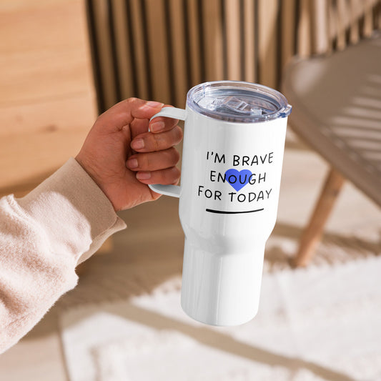 White tumbler with motivational quote held by a person in a cozy indoor setting