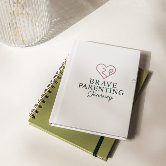 Notebook titled 'Brave Parenting Journey' on a light surface
