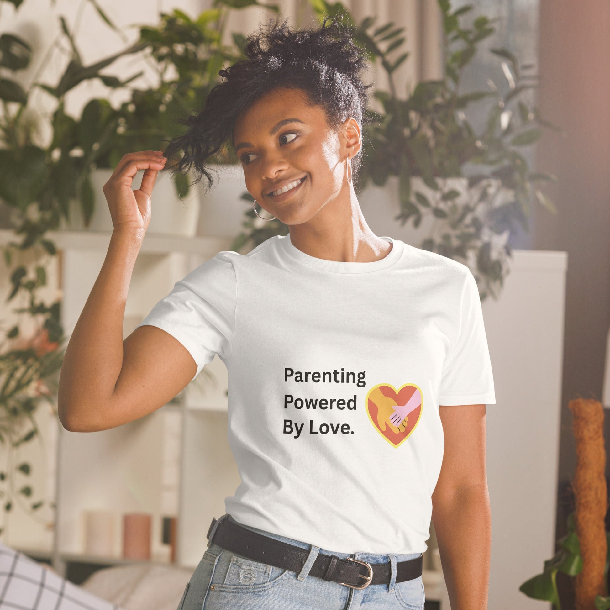 Woman wearing a white t-shirt with 'Parenting Powered By Love' text and heart graphic.