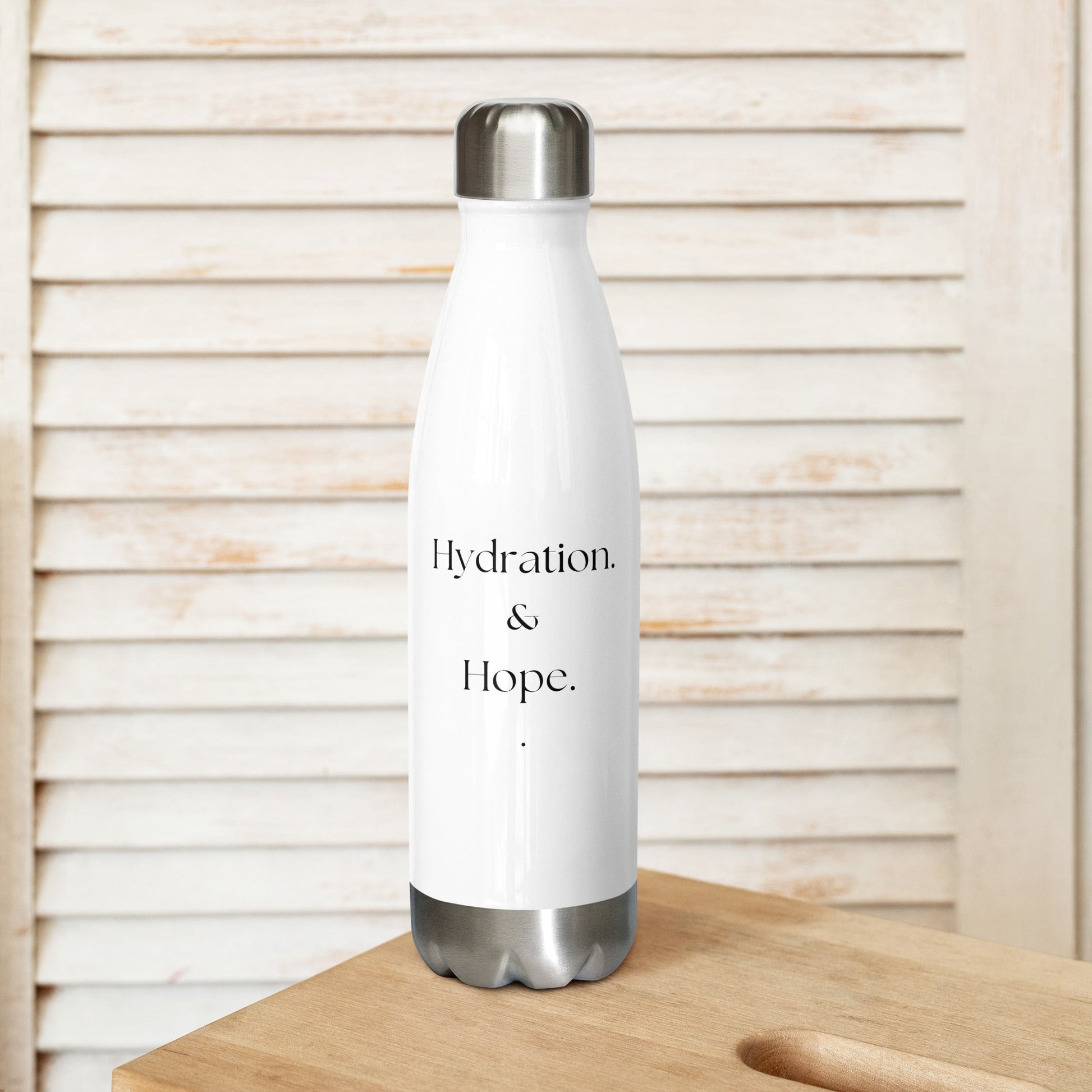 White water bottle with 'Hydration & Hope' text on a wooden surface with a light wooden panel background