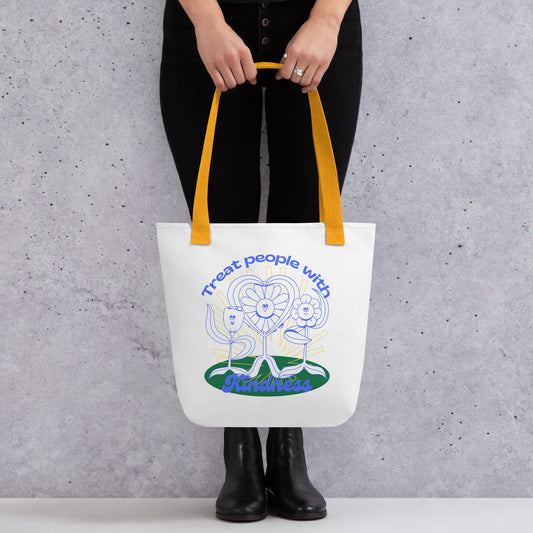 Tote bag with a design and text held by a person against a gray background