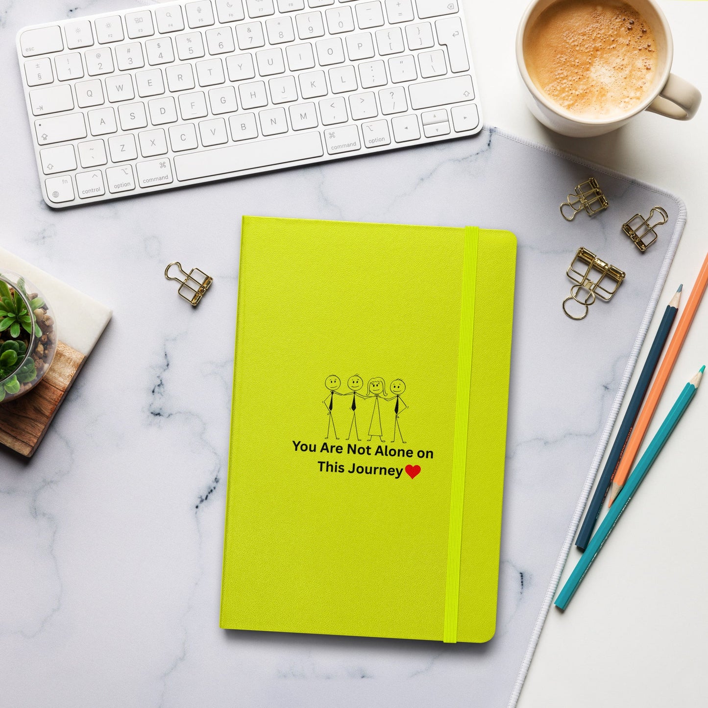 Yellow notebook with motivational quote on a marble desk with office supplies