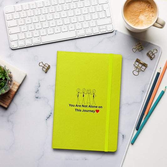 Yellow notebook with motivational quote on a marble desk with office supplies