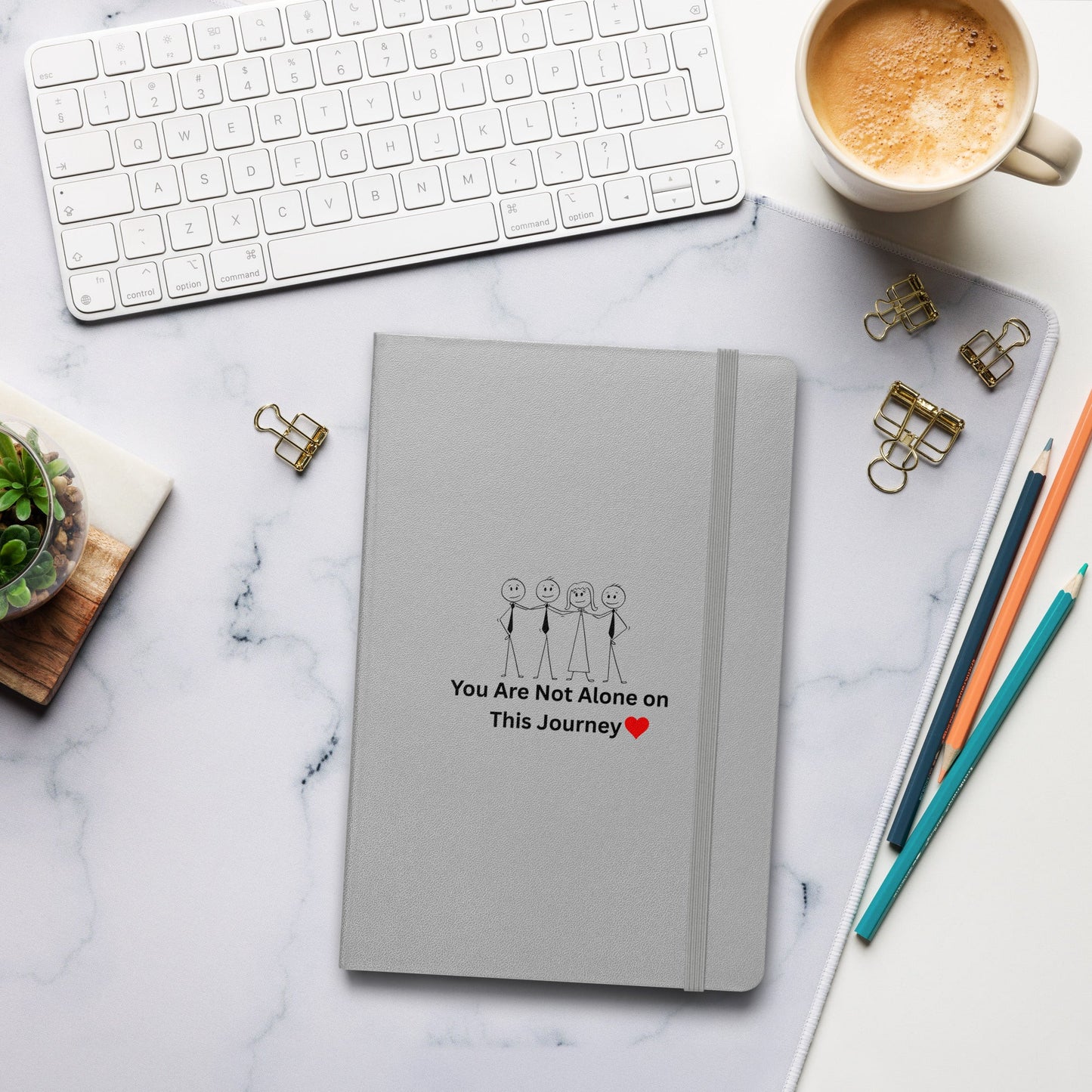 Gray notebook with motivational quote on a marble desk with office supplies