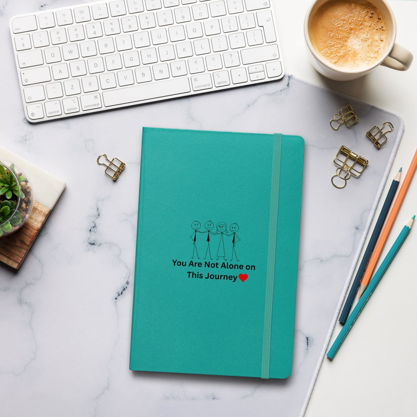 Teal notebook with motivational quote on a marble desk with office supplies