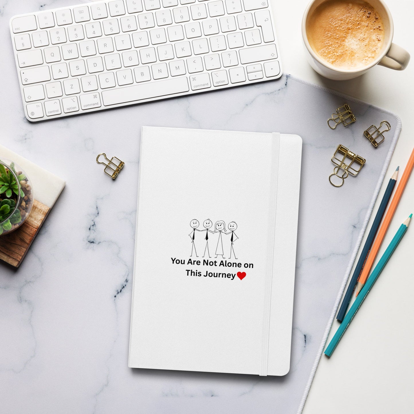 Notebook with motivational quote on a marble desk with office supplies